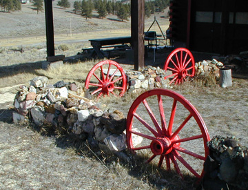 Cheery Red Wagon Wheels integrated into a stone wall surround the front of the main Ranch house........